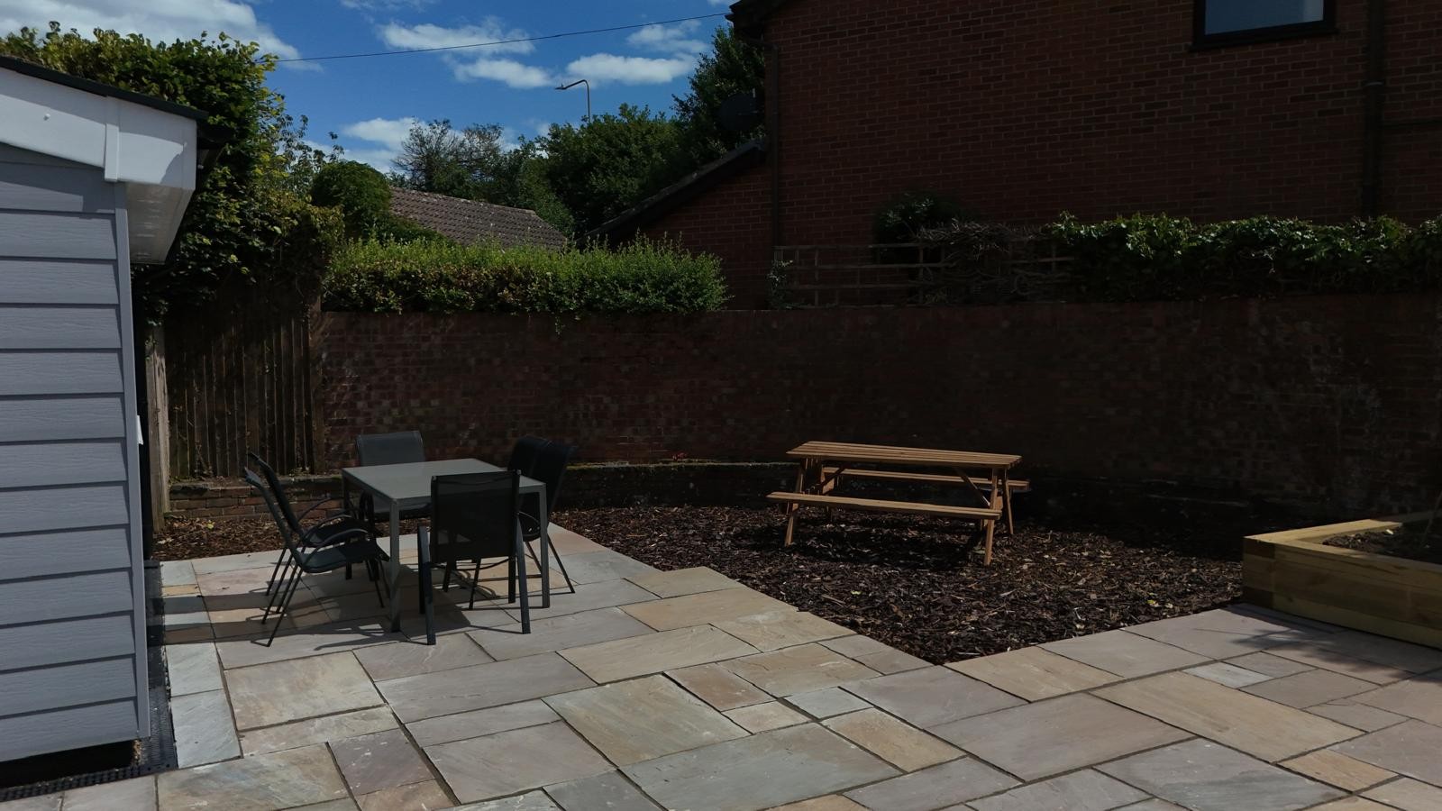 Victoria House garden patio with seating and picnic bench